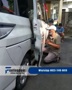 teknisi ahli dari service sliding door mobil sedang mengerjakan perbaikan sliding door mobil